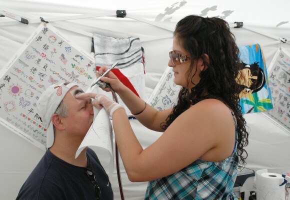 Rick Kingsbury, owner of TanFastics gets an air brush tattoo from Savannah 