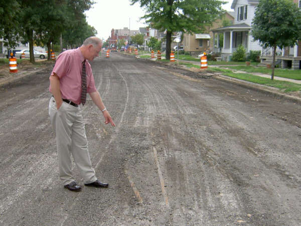 Tom Newsham checks out old trolley tracks uncovered in sewer work on Henry Street.