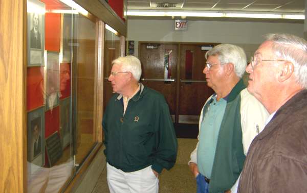 Former principal George Stevenson, center, gives a mini-tour of the heritage displays in the old high school senior hallway at T.L. Handy Middle School. Checking displays are 1954 grad Dave Klippert, left, and former teacher Bob Davidson.