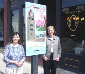 Candace Bales Right), Exec. Director of the Bay City Downtown Mgmt Board and Asst. Brandi Cramer admire one of the 100s Art Panels on display in Bay City for the upcoming weekend. This panel, in front of Old City Hall was created by BCC's Paul Valencia.