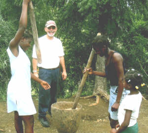 Randy Wackerle watches two Haitian girls pounding grain into meal. Wackerle took over 200 photos during his trip.