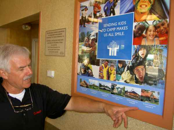 Bruce Filipich, Bay area Tim Horton's franchise holder, points to picture of Tim Horton's Charitable Foundation camp in Campbellsville, Kentucky, where six local children will attend by virtue of Wednesday's Camp Day fundraiser.