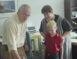 Trisha Rutherford enrolls her son, Aaron, 7, in the fourth grade with Principal Bill Ignatowski of the Bay County Public School Academy